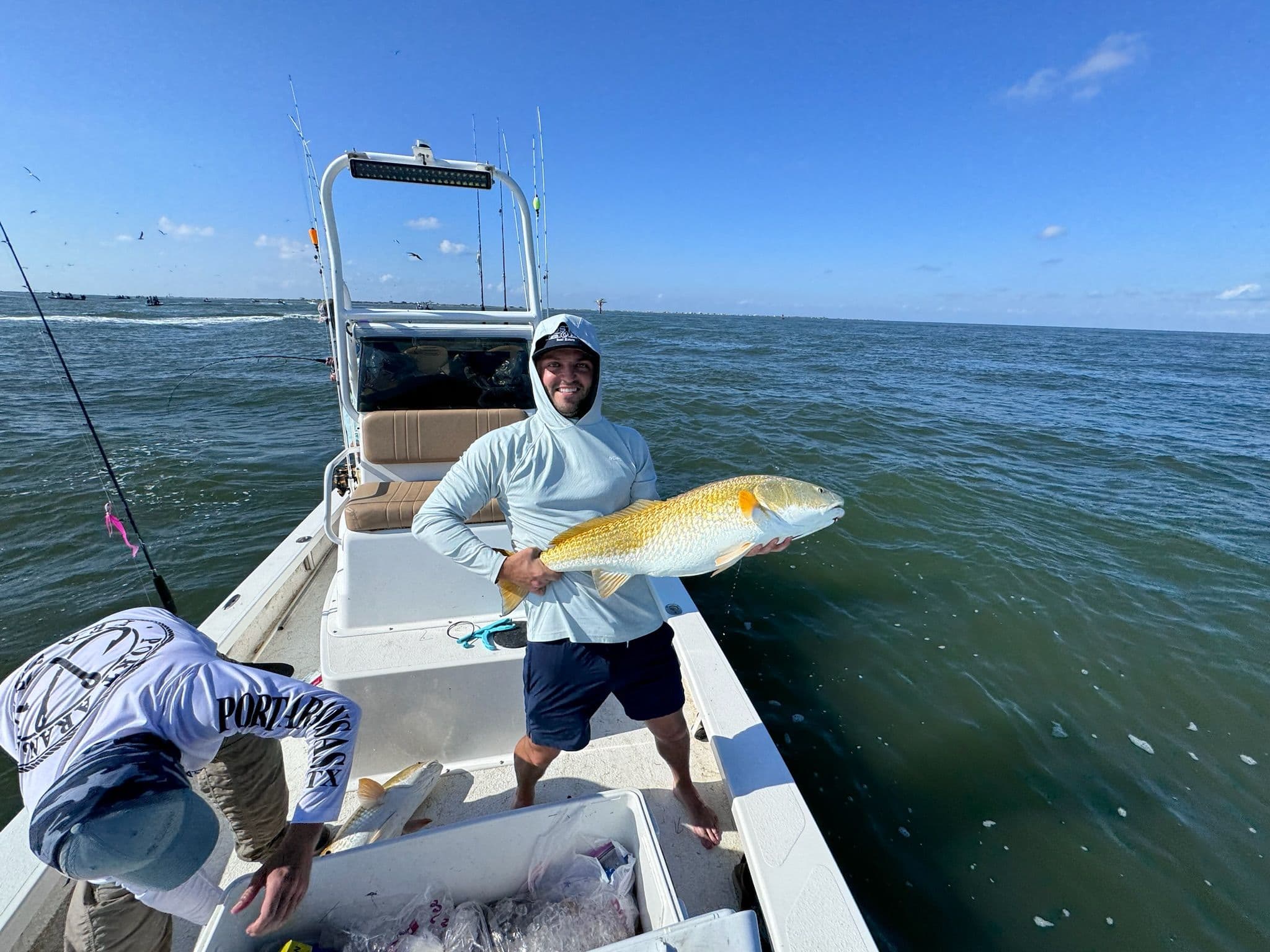Brian Cook holds a fish on a boat